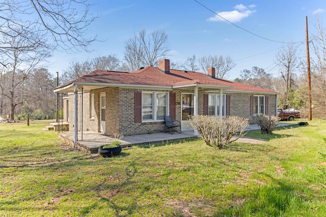 163 Railroad St, Enoree, SC 29335 - back of house with brick siding, a lawn, a chimney, and a porch