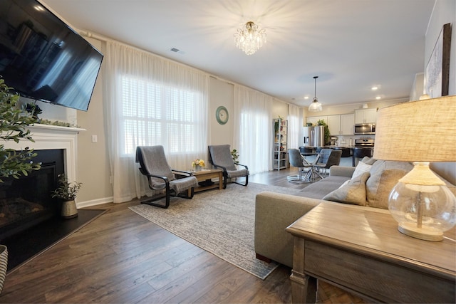 1470 Talley Ridge Dr, Woodruff, SC 29388 - living room with a fireplace with raised hearth, dark wood-style flooring, a chandelier, and recessed lighting