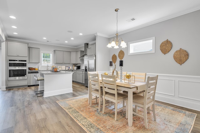 1034 Silverbend Trl, Duncan, SC 29334 - dining space with crown molding, a chandelier, light wood finished floors, recessed lighting, and wainscoting
