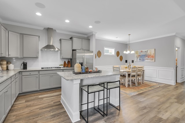 1034 Silverbend Trl, Duncan, SC 29334 - kitchen featuring gray cabinets, appliances with stainless steel finishes, wall chimney range hood, crown molding, and light wood-style flooring