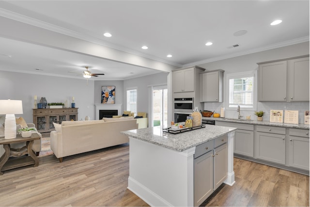 1034 Silverbend Trl, Duncan, SC 29334 - kitchen with gray cabinetry, light wood-type flooring, a center island, ceiling fan, and crown molding