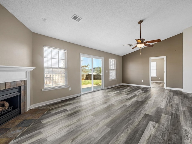 461 Candleglow Dr, Boiling Springs, SC 29316 - unfurnished living room featuring a tile fireplace, wood finished floors, a ceiling fan, a textured ceiling, and vaulted ceiling