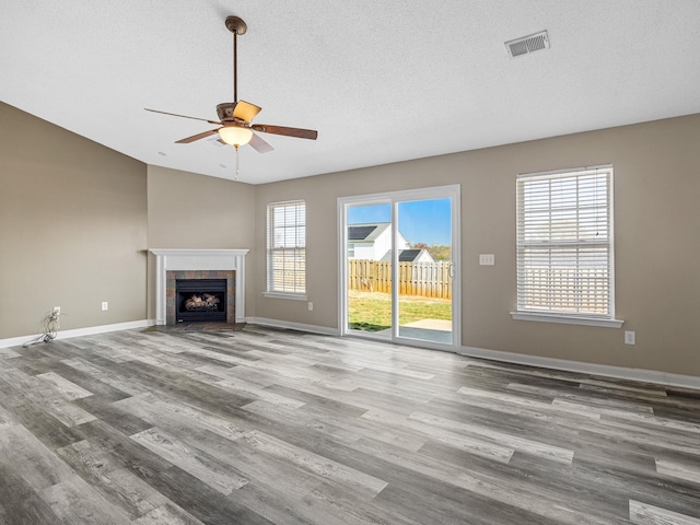 461 Candleglow Dr, Boiling Springs, SC 29316 - unfurnished living room with ceiling fan, wood finished floors, a tiled fireplace, a textured ceiling, and vaulted ceiling