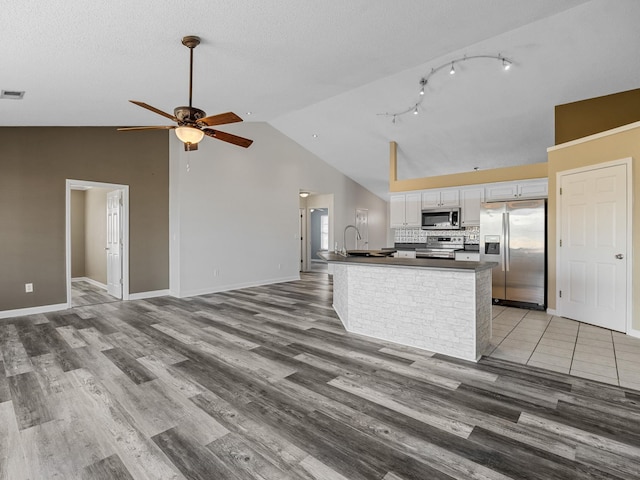 461 Candleglow Dr, Boiling Springs, SC 29316 - kitchen with stainless steel appliances, dark countertops, light wood-style floors, white cabinets, and a ceiling fan