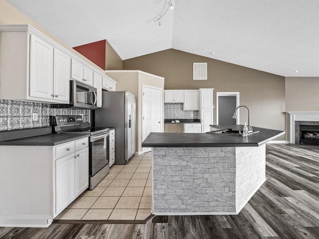 461 Candleglow Dr, Boiling Springs, SC 29316 - kitchen featuring appliances with stainless steel finishes, dark countertops, white cabinetry, lofted ceiling, and backsplash