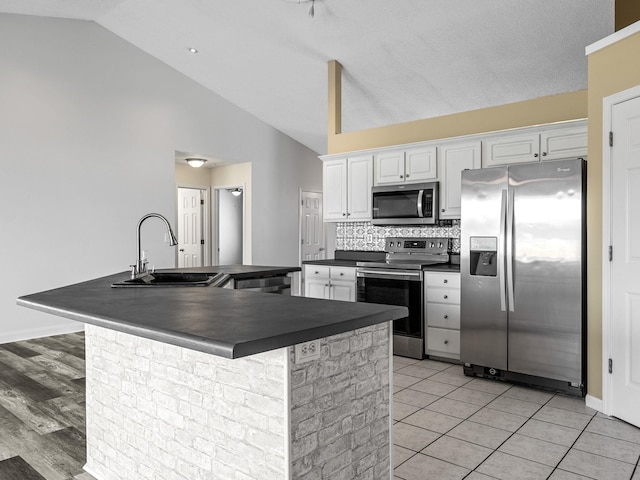 461 Candleglow Dr, Boiling Springs, SC 29316 - kitchen with appliances with stainless steel finishes, dark countertops, white cabinetry, tasteful backsplash, and high vaulted ceiling
