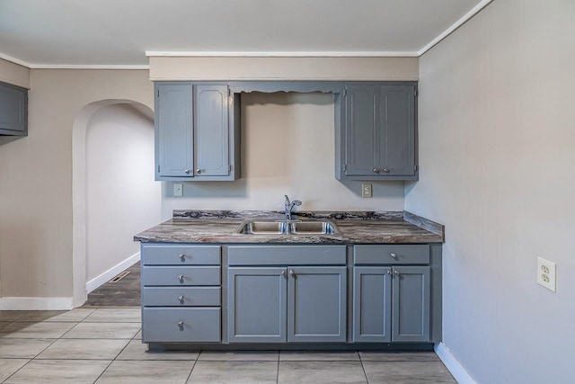 107 Ravenscroft St, Union, SC 29379 - kitchen featuring dark countertops, gray cabinetry, arched walkways, and ornamental molding