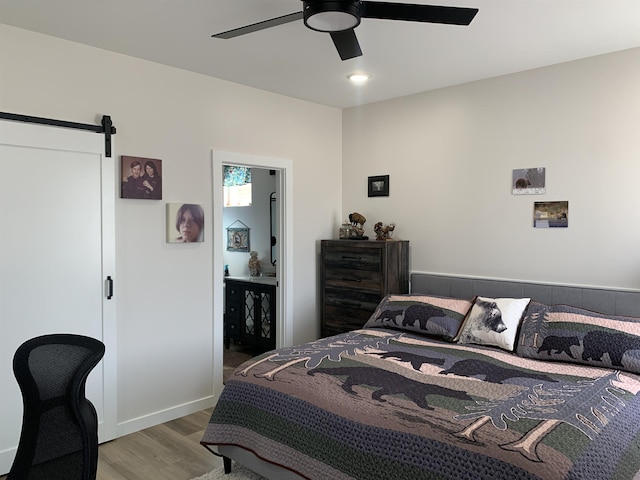 138 Lowe Rd, Chesnee, SC 29323 - bedroom with wood finished floors, a barn door, a ceiling fan, and connected bathroom