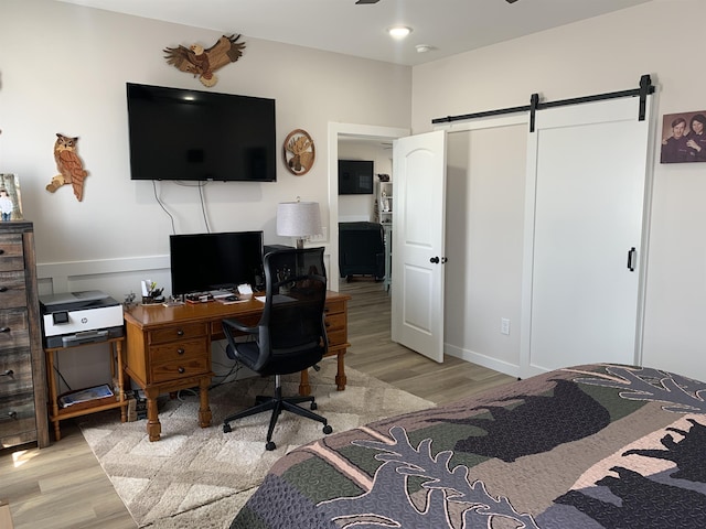 138 Lowe Rd, Chesnee, SC 29323 - bedroom with a barn door, light wood-type flooring, and an office area