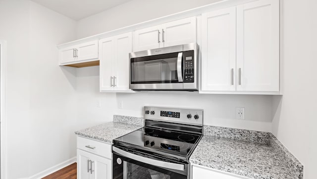 110 Sunriff Ct, Greer, SC 29651 - kitchen with appliances with stainless steel finishes, white cabinetry, light stone counters, and dark wood-type flooring