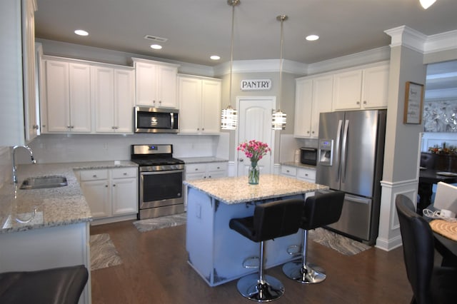 190 Colfax Dr, Boiling Springs, SC 29316 - kitchen with appliances with stainless steel finishes, ornamental molding, a kitchen island, white cabinets, and tasteful backsplash