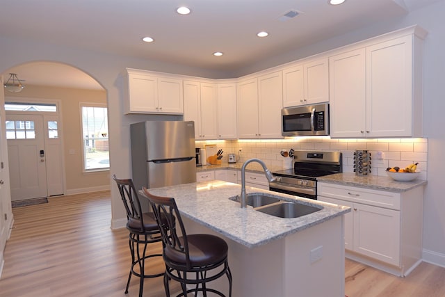 2054 Lachaise Ln, Moore, SC 29369 - kitchen featuring appliances with stainless steel finishes, light wood-type flooring, arched walkways, backsplash, and recessed lighting