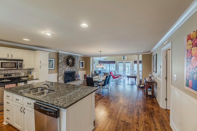 423 Coggins Shore Rd, Inman, SC 29349 - kitchen featuring stainless steel appliances, a fireplace, crown molding, open floor plan, and dark wood-style flooring