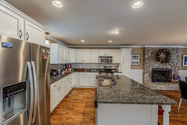 423 Coggins Shore Rd, Inman, SC 29349 - kitchen featuring appliances with stainless steel finishes, ornamental molding, wood finished floors, a kitchen island with sink, and white cabinets