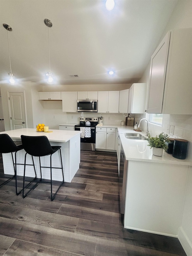 776 Darwin Rd, Gaffney, SC 29340 - kitchen with stainless steel appliances, dark wood finished floors, white cabinets, a center island, and a kitchen bar
