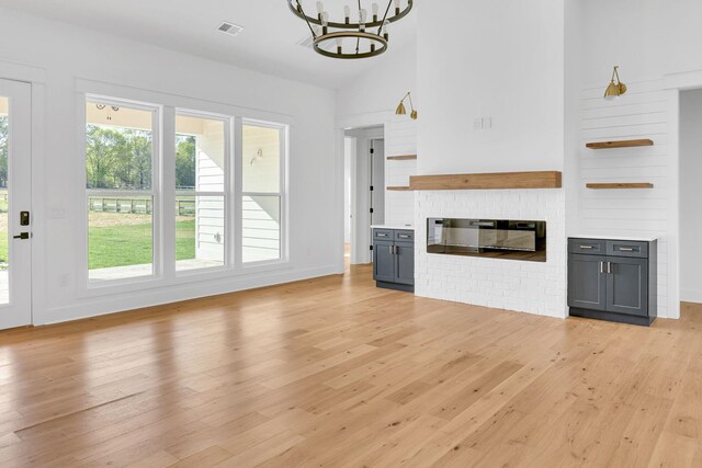 164 Triangle Pine Rd, Fountain Inn, SC 29644 - unfurnished living room with a chandelier, light wood-style floors, and vaulted ceiling