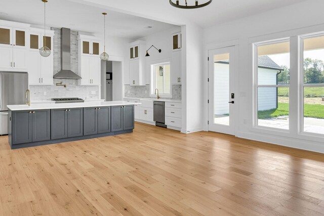 164 Triangle Pine Rd, Fountain Inn, SC 29644 - kitchen featuring wall chimney range hood, appliances with stainless steel finishes, white cabinets, light countertops, and backsplash
