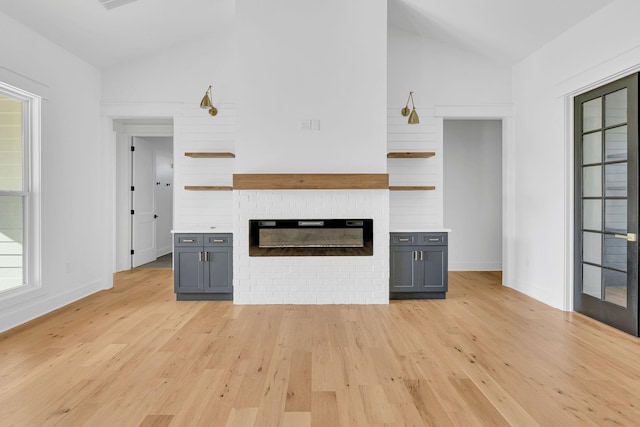 164 Triangle Pine Rd, Fountain Inn, SC 29644 - unfurnished living room featuring lofted ceiling, light wood-type flooring, and a fireplace