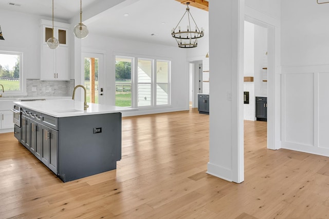 164 Triangle Pine Rd, Fountain Inn, SC 29644 - kitchen with white cabinetry, light countertops, a chandelier, light wood finished floors, and a decorative wall