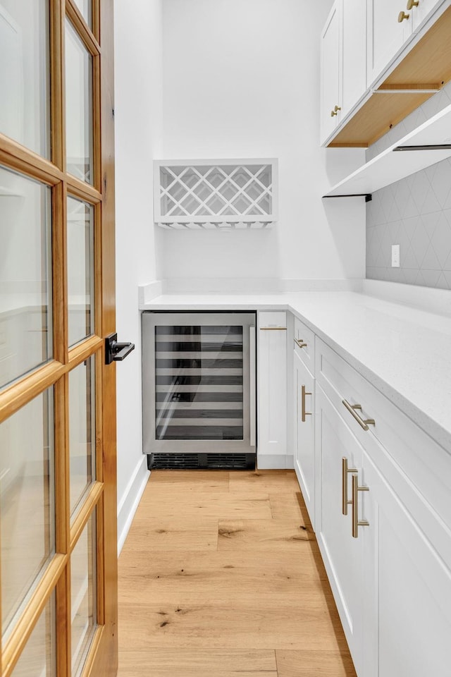 164 Triangle Pine Rd, Fountain Inn, SC 29644 - indoor dry bar with wine cooler, light wood-style flooring, and tasteful backsplash
