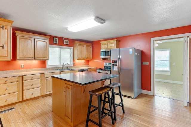 1620 Rainbow Lake Rd, Inman, SC 29349 - kitchen with appliances with stainless steel finishes, a breakfast bar, healthy amount of natural light, a center island, and a textured ceiling