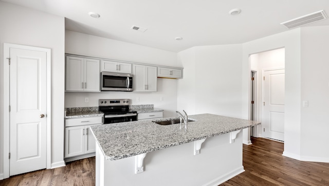 108 Sunriff Ct, Greer, SC 29651 - kitchen with stainless steel appliances, dark wood-type flooring, light stone counters, and a breakfast bar area