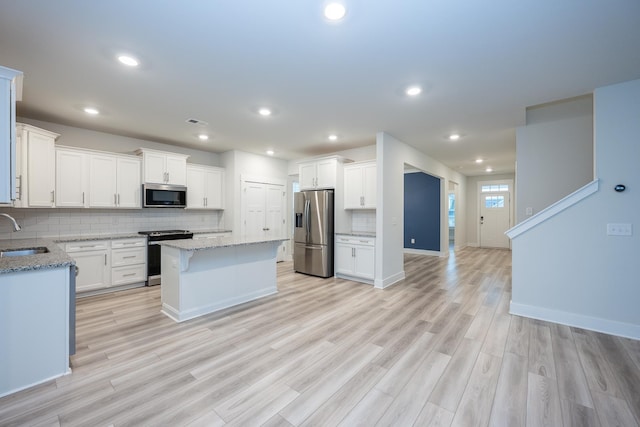 832 Redmill Ln, Duncan, SC 29334 - kitchen with stainless steel appliances, a center island, backsplash, white cabinetry, and recessed lighting