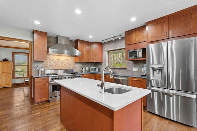 116 Dorothy Ln, Pickens, SC 29671 - kitchen with appliances with stainless steel finishes, wall chimney range hood, brown cabinetry, wood finished floors, and recessed lighting