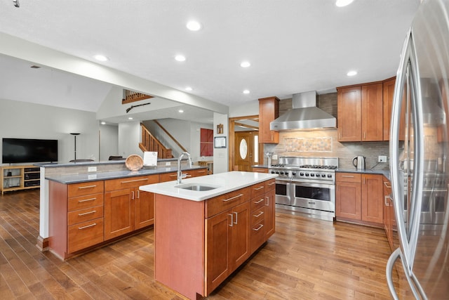 116 Dorothy Ln, Pickens, SC 29671 - kitchen featuring appliances with stainless steel finishes, wall chimney exhaust hood, a center island with sink, open floor plan, and wood finished floors
