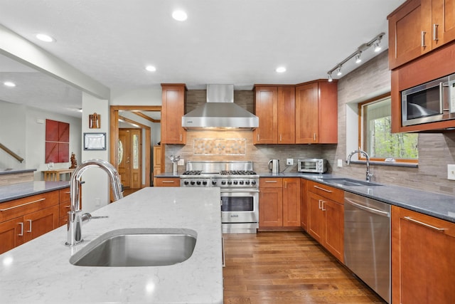 116 Dorothy Ln, Pickens, SC 29671 - kitchen featuring wall chimney exhaust hood, stainless steel appliances, light stone countertops, light wood-type flooring, and decorative backsplash