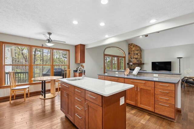 116 Dorothy Ln, Pickens, SC 29671 - kitchen featuring a kitchen island with sink, open floor plan, hardwood / wood-style flooring, a textured ceiling, and brown cabinets