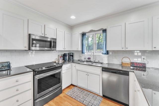 101 Owens Dr, Inman, SC 29349 - kitchen with appliances with stainless steel finishes, ornamental molding, white cabinets, light wood-style floors, and recessed lighting
