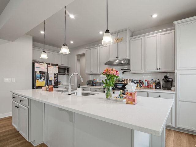 1848 Sourwood Dr, Woodruff, SC 29388 - kitchen with stainless steel appliances, under cabinet range hood, tasteful backsplash, light wood finished floors, and recessed lighting