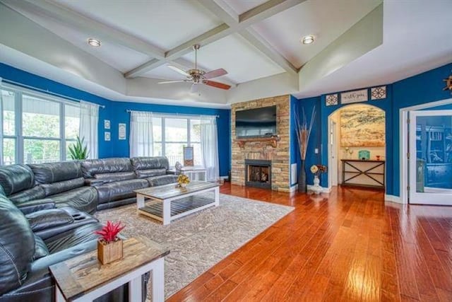 217 Aqua Cove Ct, Inman, SC 29349 - living area featuring beamed ceiling, healthy amount of natural light, wood finished floors, a ceiling fan, and a stone fireplace