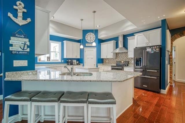 217 Aqua Cove Ct, Inman, SC 29349 - kitchen featuring stainless steel appliances, wall chimney range hood, white cabinetry, and dark wood-type flooring