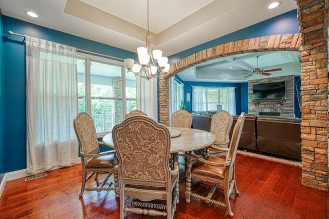 217 Aqua Cove Ct, Inman, SC 29349 - dining space featuring a raised ceiling, hardwood / wood-style floors, a chandelier, ceiling fan, and a fireplace
