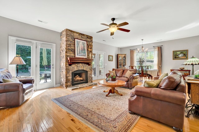204 Lord Byron Ln, Travelers Rest, SC 29690 - living area with a chandelier, a ceiling fan, light wood-style floors, and a stone fireplace