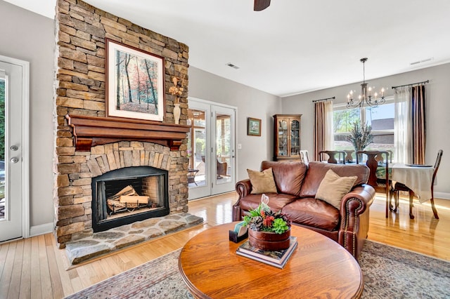 204 Lord Byron Ln, Travelers Rest, SC 29690 - living room featuring a chandelier, wood-type flooring, and a stone fireplace