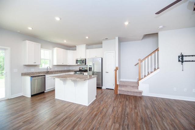 521 Preakness Run, Spartanburg, SC 29301 - kitchen featuring appliances with stainless steel finishes, ceiling fan, a center island, white cabinetry, and dark wood-style floors