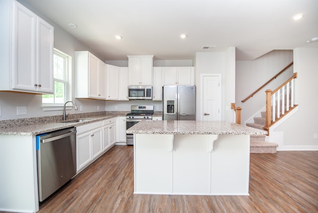 521 Preakness Run, Spartanburg, SC 29301 - kitchen with stainless steel appliances, a kitchen island, wood finished floors, white cabinetry, and recessed lighting