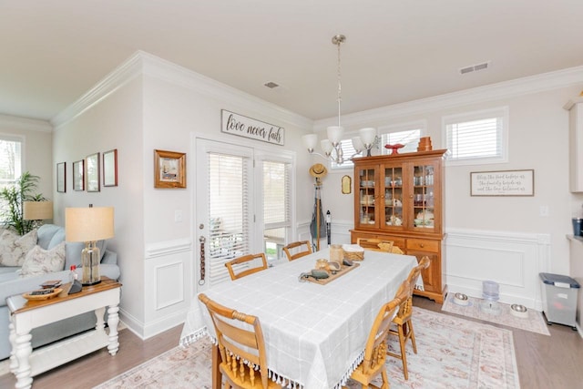 5 Yellow Fox Rd, Greer, SC 29650 - dining space with crown molding, a wainscoted wall, a decorative wall, light wood finished floors, and a chandelier