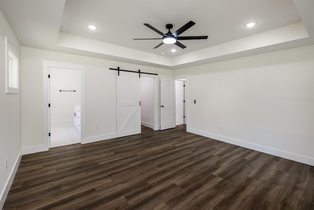 7 Campbell Mill Rd, Traveleres Rest, SC 29690 - unfurnished bedroom with a raised ceiling, dark wood-style floors, a barn door, recessed lighting, and connected bathroom