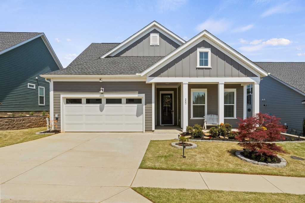 203 Glendon St, Greer, SC 29651 - craftsman-style home with board and batten siding, a garage, a front lawn, driveway, and covered porch
