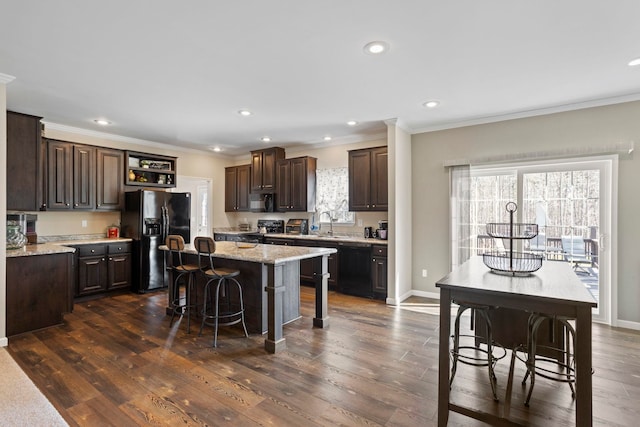 140 Vera Ln, Columbus, NC 28722 - kitchen with black appliances, dark brown cabinets, a kitchen island, a breakfast bar, and ornamental molding