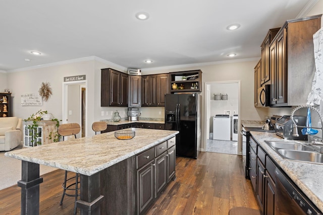 140 Vera Ln, Columbus, NC 28722 - kitchen with black appliances, independent washer and dryer, a kitchen bar, dark wood-style floors, and crown molding