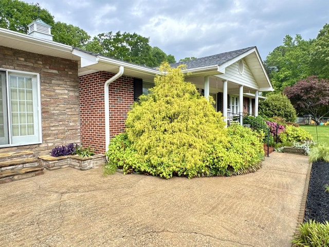 8627 Valley Falls Rd, Boiling Springs, SC 29316 - view of side of property with stone siding, a chimney, and a porch