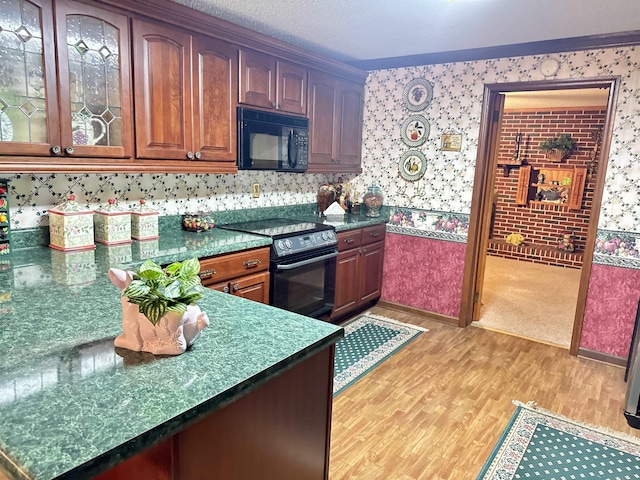 8627 Valley Falls Rd, Boiling Springs, SC 29316 - kitchen with black appliances, light wood-style flooring, wallpapered walls, glass insert cabinets, and dark countertops