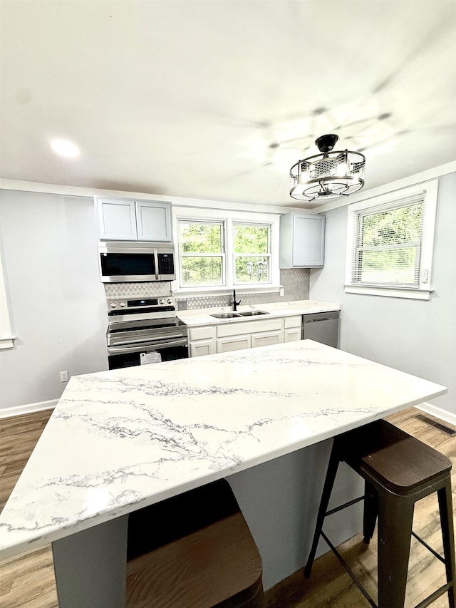 7 Pine Ln, Inman, SC 29349 - kitchen with appliances with stainless steel finishes, a kitchen bar, decorative backsplash, wood finished floors, and recessed lighting