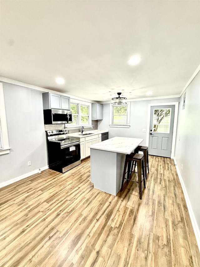 7 Pine Ln, Inman, SC 29349 - kitchen featuring stainless steel appliances, light wood-style floors, a center island, a kitchen bar, and ornamental molding