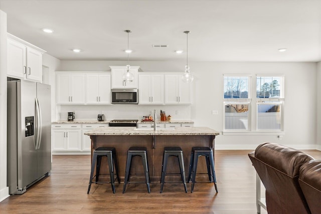 424 Granbury Dr, Duncan, SC 29334 - kitchen featuring stainless steel appliances, wood finished floors, a kitchen bar, light stone countertops, and recessed lighting